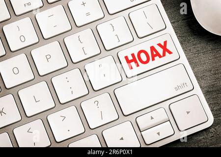 Pulsante con parola rossa Hoax sulla tastiera del computer, vista dall'alto Foto Stock