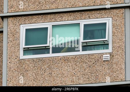 MELBOURNE, AUSTRALIA - 7 LUGLIO: Si vede un uomo che fa un segno d'amore con le mani alla sua finestra del 120 Racecourse Road Housing Complex nel terzo giorno della chiusura totale di 9 torri di altezza Housing commission a North Melbourne e Flemington durante COVID 19 il 7 luglio, 2020 a Melbourne, Australia. Dopo aver registrato un orrore 191 casi COVID-19 durante la notte costringendo il Premier Daniel Andrews ad annunciare oggi che tutta la metropolitana di Melbourne insieme ad un centro regionale, Mitchell Shire tornerà ancora una volta alla fase tre blocchi dalla mezzanotte di mercoledì 8 giugno. Il Premier ha aggiunto tha Foto Stock