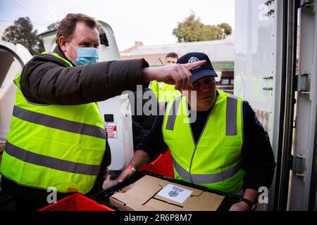 MELBOURNE, AUSTRALIA - LUGLIO 10: Victorian Trades Hall Council Secretary, Luke Hilakari (a sinistra) è visto aiutare uno sceriffo (a destra) scaricare una consegna di carne per i residenti nella torre Alfred Street Housing commission durante il COVID 19 il 10 luglio 2020 a Melbourne, Australia. L'ex leader federale del lavoro Bill Shreen, insieme a stretti alleati al Trades Hall aiutano a consegnare la carne Halal, fornita dalla Macca Halal Foods alle torri della commissione per gli alloggi bloccati dopo un'epidemia di COVID-19 rilevata all'interno del complesso. Il signor Shorn è riuscito a usare il suo alto profilo per garantire che il cibo non sia stato rovesciato da po Foto Stock