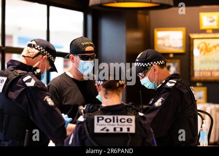 MELBOURNE, VIC - SETTEMBRE 20: La polizia pone una domanda all'interno di un bar del Chadstone Shopping Centre durante una serie di proteste pop up Freedom il 20 settembre 2020 a Melbourne, Australia. Le proteste per la libertà si tengono a Melbourne ogni sabato e domenica in risposta alle restrizioni imposte dal COVID-19 e alla continua rimozione delle libertà nonostante i nuovi casi siano in declino. Victoria ha registrato altri 14 nuovi casi durante la notte con 7 morti. Foto Stock