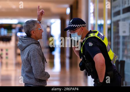 MELBOURNE, VIC - SETTEMBRE 20: Un poliziotto interroga un uomo all'interno del Chadstone Shopping Centre durante una serie di proteste pop up Freedom il 20 settembre 2020 a Melbourne, Australia. Le proteste per la libertà si tengono a Melbourne ogni sabato e domenica in risposta alle restrizioni imposte dal COVID-19 e alla continua rimozione delle libertà nonostante i nuovi casi siano in declino. Victoria ha registrato altri 14 nuovi casi durante la notte con 7 morti. Foto Stock