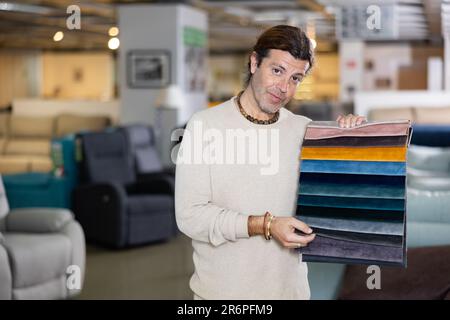 Uomo di mezza età mostra tessuto di tappezzeria Foto Stock