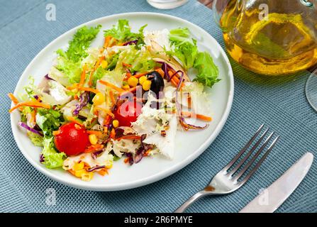 Piatto di deliziosa insalata a base di lattuga, pomodori, mais, cipolle Foto Stock