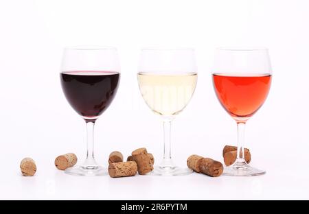 Tre bicchieri da vino e tappi sullo sfondo. Foto Stock