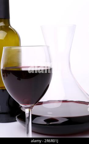 Decanter, bottiglia e bicchiere di vino sul terreno bianco del forno Foto Stock