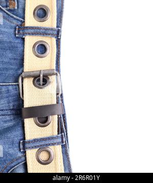I jeans blu e la cintura in pelle si trovano a sinistra sullo sfondo bianco Foto Stock