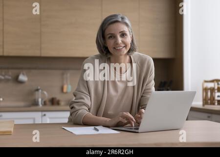 Allegro positivo maturo donna freelance business educando per un nuovo lavoro Foto Stock
