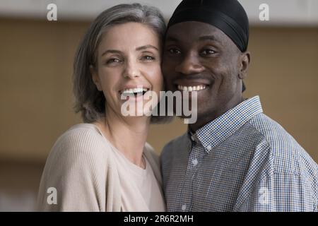 Felice coppia diversa africana e caucasica in posa al coperto Foto Stock