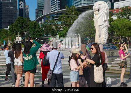 Turisti cinesi che si aggirano intorno al Merlion, statua di mezzo leone a forma di pesce, al Merlion Park, Singapore Foto Stock