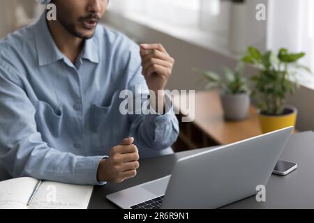 Giovane insegnante indiano on-line che parla al computer portatile Foto Stock