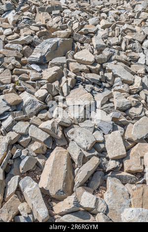 Campo di pietra di hardcore rotta in luce solare brillante. Essendo usato per correggere la strada fatiscente della fattoria di paese. Pietra più grande circa 25cm. Caduta su terreno roccioso Foto Stock
