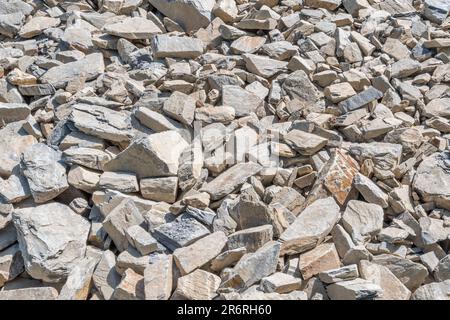 Campo di pietra di hardcore rotta in luce solare brillante. Essendo usato per correggere la strada fatiscente della fattoria di paese. Pietra più grande circa 25cm. Caduta su terreno roccioso Foto Stock