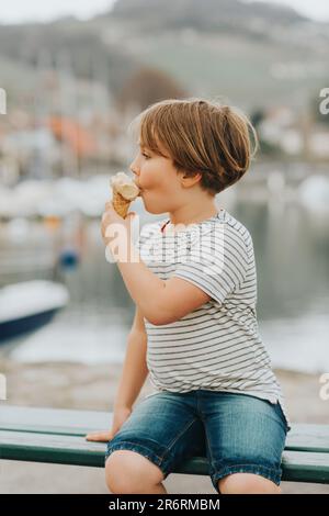 Ritratto all'aperto di un simpatico ragazzino che mangia gelato in una giornata calda Foto Stock