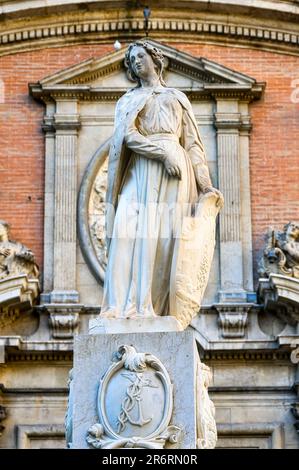 Valencia, Spagna - 15 luglio 2022: Statua di marmo di una donna romana. La scultura si trova di fronte ad un edificio in mattoni. Foto Stock