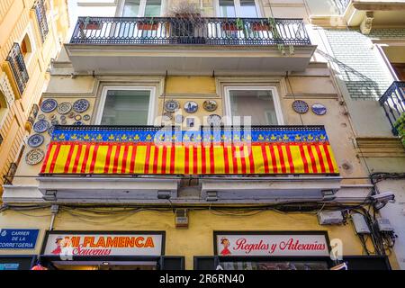 Valencia, Spagna - 15 luglio 2022: Un edificio commerciale con balconi e piastre in ceramica sul muro. Sulla proprietà sono presenti cartelli per gli affari. Foto Stock