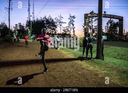 (230611) -- ITEN, 11 giugno 2023 (Xinhua) -- il corridore keniota Kelvin Kittai Chepsigor (fronte L) dell'Università di Kisii si scalda prima di una sessione mattutina del campo di addestramento locale a Iten, Kenya, il 5 giugno 2023. Alle 6:00, la prima luce del mattino splende sull'arco storico scritto con "Casa dei campioni" in Iten, i corridori si sono riuniti qui per salutarsi con un pugno, allungare i muscoli e prepararsi per la prima sessione di allenamento della giornata. Con un'altitudine media di 2.400 metri, Iten si trova nella parte occidentale del Kenya, vicino alla Great Rift Valley dell'Africa orientale. È un lon ideale Foto Stock