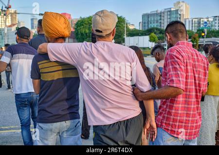 I lavoratori del Punjab, India, apparentemente amici, durante la loro giornata trascorsa a Little India, Singapore; a sinistra: Un Sikh con i tradizionali turbanti Foto Stock