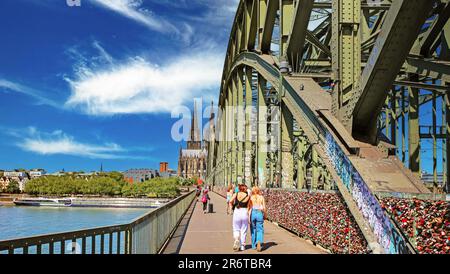 Colonia (Köln), Germania - Giugno 6. Giorno 2023: Percorso ciclabile e pedonale sul ponte sul reno di Hohenzollern fino alla cattedrale a cupola nella soleggiata giornata estiva Foto Stock