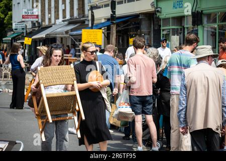 Londra, Regno Unito. 11 giugno 2023. Visitatori con acquisti presso la Church Street Antiques Fair di Marylebone che ritorna dopo quattro anni. Oltre 60 commercianti di antiquariato, d'epoca e d'arte da tutta Londra e dal Regno Unito, oltre ai 18 negozi di antiquariato e gallerie su Church Street, e i 80 rivenditori del mercato dell'antiquariato di Alfies stanno partecipando a una celebrazione di un giorno di arte, antiquariato, vintage e design. Credit: Stephen Chung / Alamy Live News Foto Stock