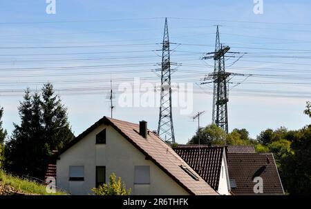 Linee elettriche aeree, piloni elettrici, piloni elettrici con edifici residenziali, elettrosmog Foto Stock