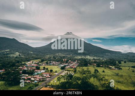 Il drone sorvola il maestoso vulcano Arenal della Costa Rica. Catturando la sua maestosa bellezza dall'alto, la possente vetta si erge come un simbolo della natura Foto Stock