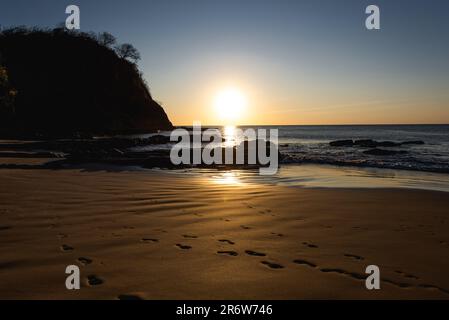 Foto del paesaggio al tramonto con cielo limpido che si affaccia sulla spiaggia sabbiosa di fronte all'oceano Atlantico in Nicaragua vicino a San Juan del Sur Foto Stock