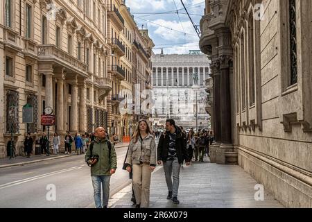 Gente che cammina lungo via del corso con sullo sfondo il monumento di Vittorio Emanuele II, Roma, Italia Foto Stock