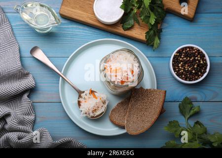 Gustosi crauti e ingredienti su un tavolo di legno azzurro, piatto Foto Stock