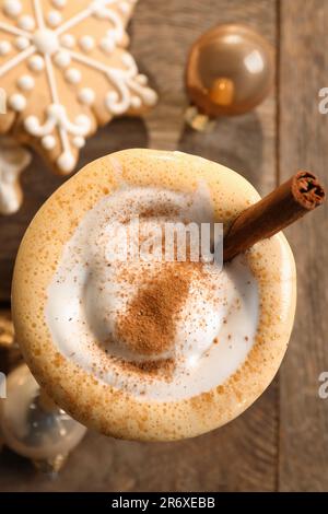 Gustoso egnog con cannella, biscotti e baubles di Natale su tavola di legno, piatto Foto Stock