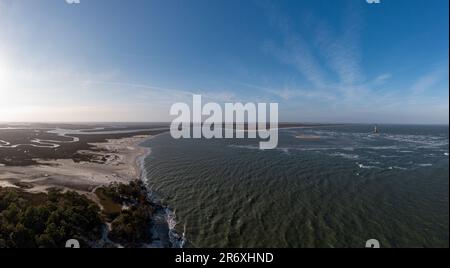 Sabbia ed erbe marine a Folly Beach vicino al faro di Morris Island a Charleston, South Carolina. Foto Stock