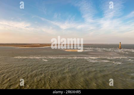 Sabbia ed erbe marine a Folly Beach vicino al faro di Morris Island a Charleston, South Carolina. Foto Stock