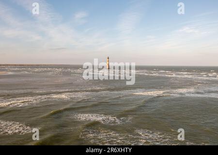 Sabbia ed erbe marine a Folly Beach vicino al faro di Morris Island a Charleston, South Carolina. Foto Stock