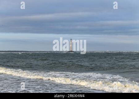 Sabbia ed erbe marine a Folly Beach vicino al faro di Morris Island a Charleston, South Carolina. Foto Stock