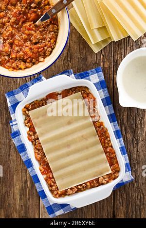 Preparazione di Lasagna in piastra rettangolare a casseruola. Sfoglia di lasagne su ragù o bolognese e beshamel o salsa bianca Foto Stock