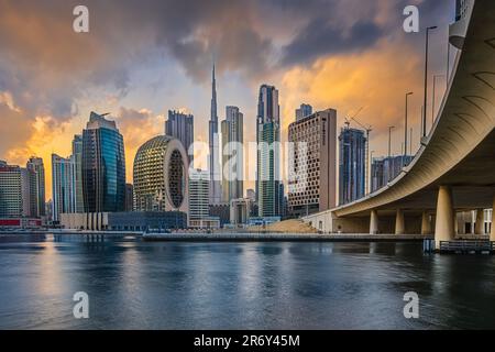 Atmosfera serale a Dubai. Tramonto con lo skyline della città negli Emirati. Cieli nuvolosi con grattacieli che si affacciano sul Burj Khalifa. Facciata vetrata di grattacieli. Foto Stock