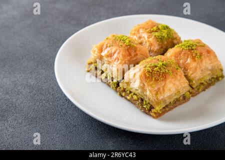 Baklava turca al pistacchio su un piatto bianco. Baklava turca tradizionale deliziosa Foto Stock