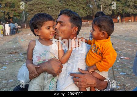 New Delhi, India - 10 novembre 2011: Fiero padre pone con i suoi figli Delhi, India. Nel 1952, l'India lancia una campagna di mass media per diffondere il Foto Stock