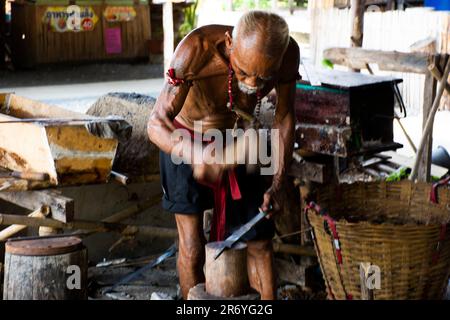 Thai oldman persone fabbro o metalaio che fanno antiche armature di ferro e metallo d'acciaio armi antiche in bottega di fabbro locale di Bang Rachan villaggio a Foto Stock