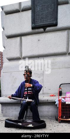 Un uomo cinese che suona il suo strumento musicale ad archi a Chinatown, New York, USA. Foto Stock