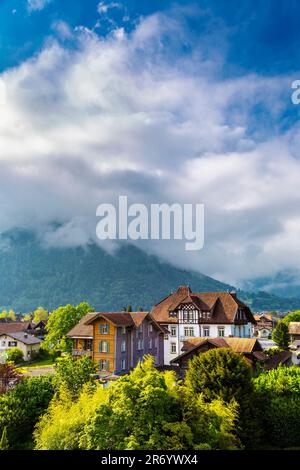 Vista sulle case e le montagne svizzere in stile tradizionale a Matten bei Interlaken, Svizzera Foto Stock