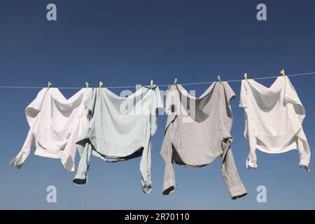 Linea di lavaggio con asciuga abiti e vestiario sotto il cielo blu Foto Stock