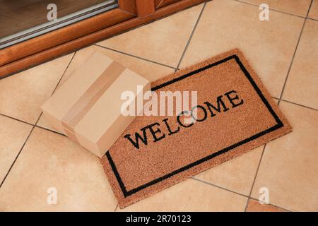 Pacco sul tappetino vicino alla porta anteriore interna, vista dall'alto Foto Stock