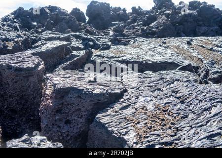 Varietà di forme di lava solidificata di basalto. lastra di lava, saturazione di gas negli strati inferiori Foto Stock