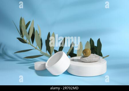 Vasetti di crema d'oliva su sfondo azzurro. Prodotti cosmetici Foto Stock