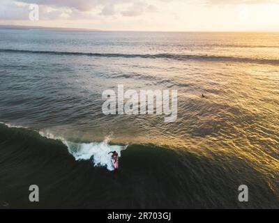 Surfista equitazione onda, Kuta, Bali, Indonesia Foto Stock