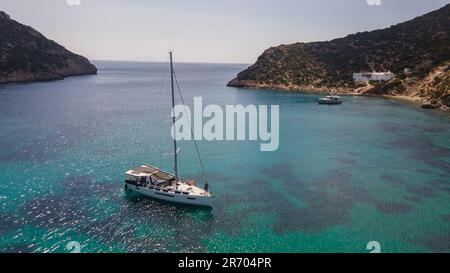 Una barca a vela nella baia di Fikiatha, sull'isola di Sifnos, Grecia Foto Stock