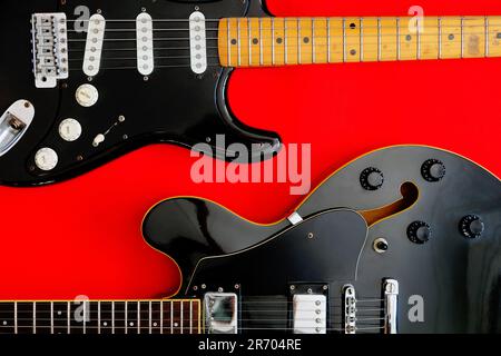 Chitarra elettrica su sfondo rosso. Foto Stock