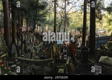 Una vista del cimitero all'aperto nel Santuario di Fushimi Inari Taisha in Giappone, caratterizzato da architettura Giapponese tradizionale Foto Stock