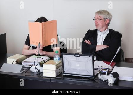 Amburgo, Germania. 12th giugno, 2023. Uno dei due imputati copre il suo volto accanto all'avvocato Andreas trode (r) durante il proseguimento della procedura di protezione dello Stato nel Palazzo di Giustizia penale. L'accusa federale accusa un russo di 18 anni di Bremerhaven e un kosovaro tedesco di 16 anni di Iserlohn di sostenere lo "Stato islamico" (IS) tedesco o, nel caso del vecchio imputato, di aderire ALL'IS come membri. Secondo l'accusa, il più giovane convenuto ha previsto di effettuare un attacco in Germania a nome DELL'IS. Credit: Ulrich Perrey/dpa/Alamy Live News Foto Stock