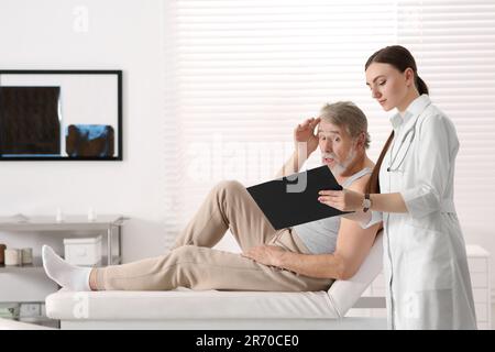 Paziente professionale di consulenza ortopedica femminile in clinica Foto Stock